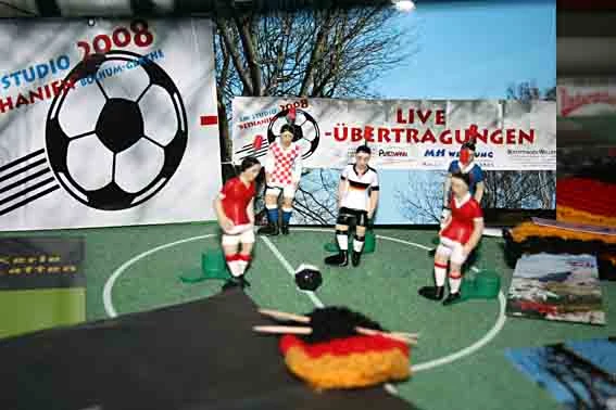 Tipp-Kick-Figuren verschiendener Nationalitäten auf dem Spielfeld.