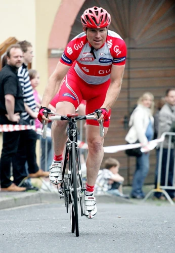 Andreas Beikirch im roten Sparkassentrikot beim Antritt auf dem Rad.