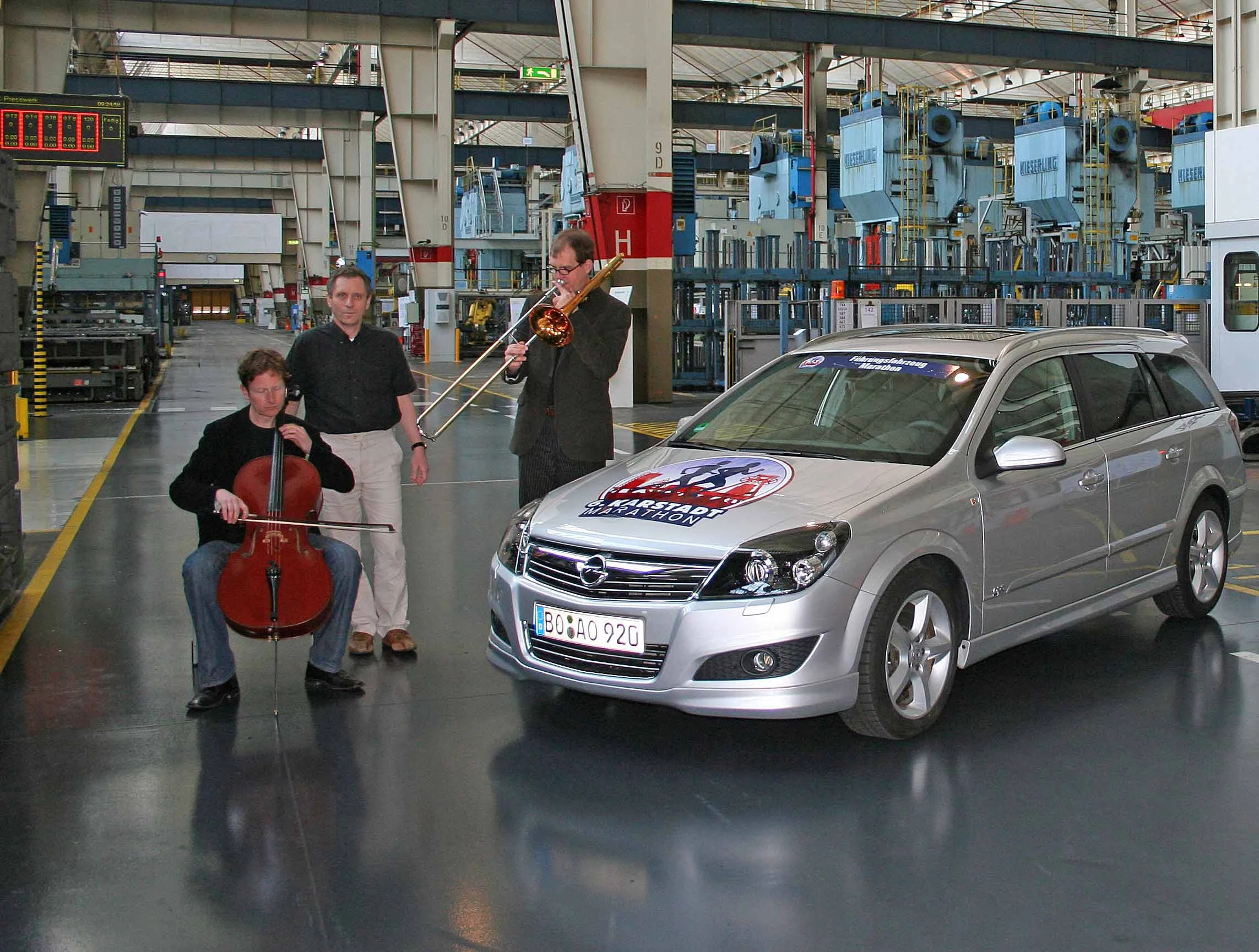 Klassik-Trio im Opel-Werk neben silbernem Astra.