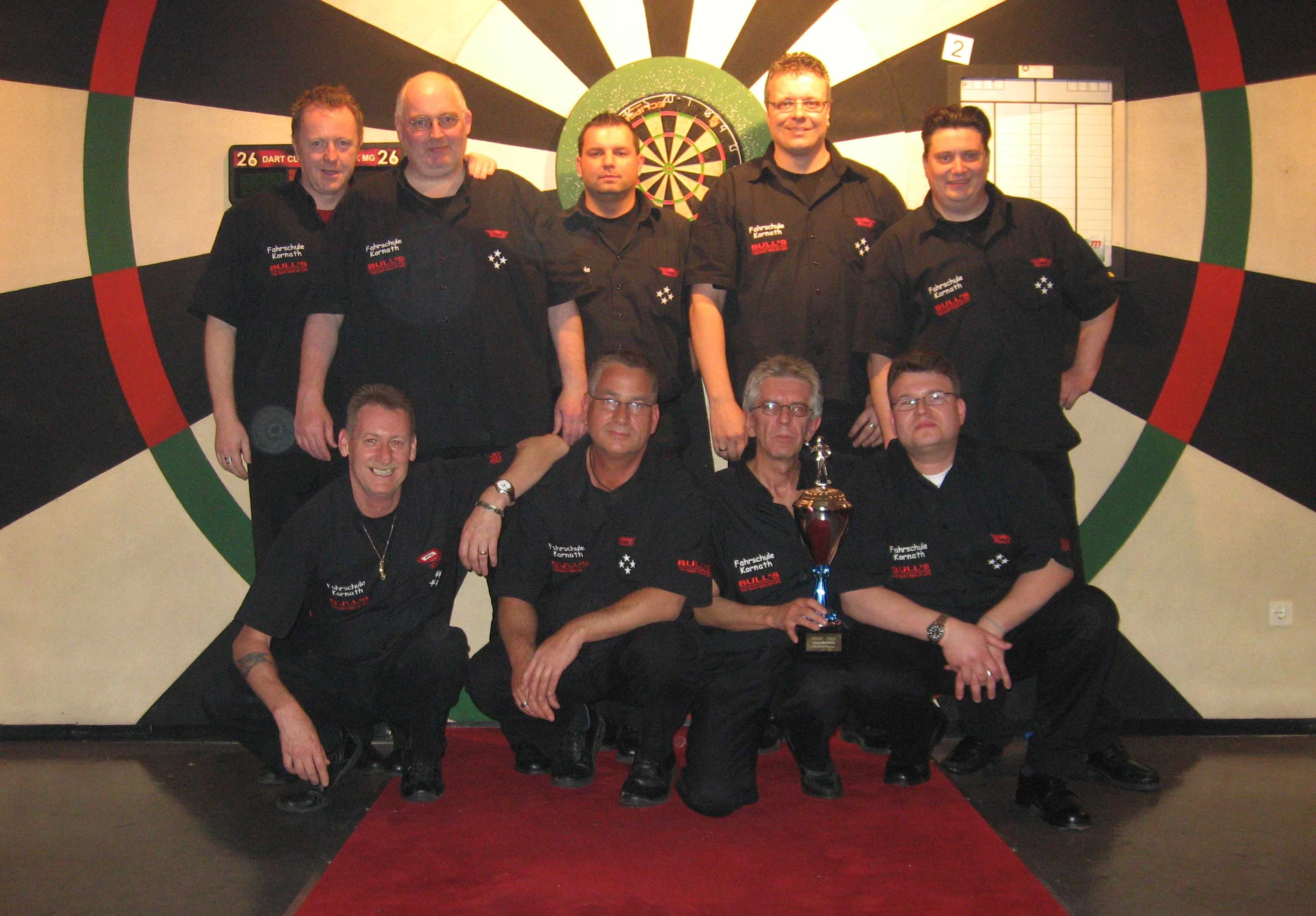 Dartteam in schwarzen Trikots mit Pokal
