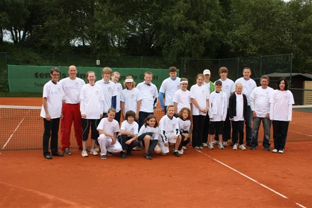 Mit weißen T-Shirts bekleidete Tennisspielergruppe
