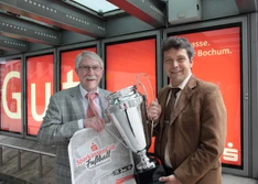Ulrich Jeromin, Fußballkreis Bochum (l.), und Jürgen Dieberg, Sparkasse Bochum, zeigen sich voller Vorfreude mit dem eindrucksvollen Wanderpokal für den künftigen Kreismeister.