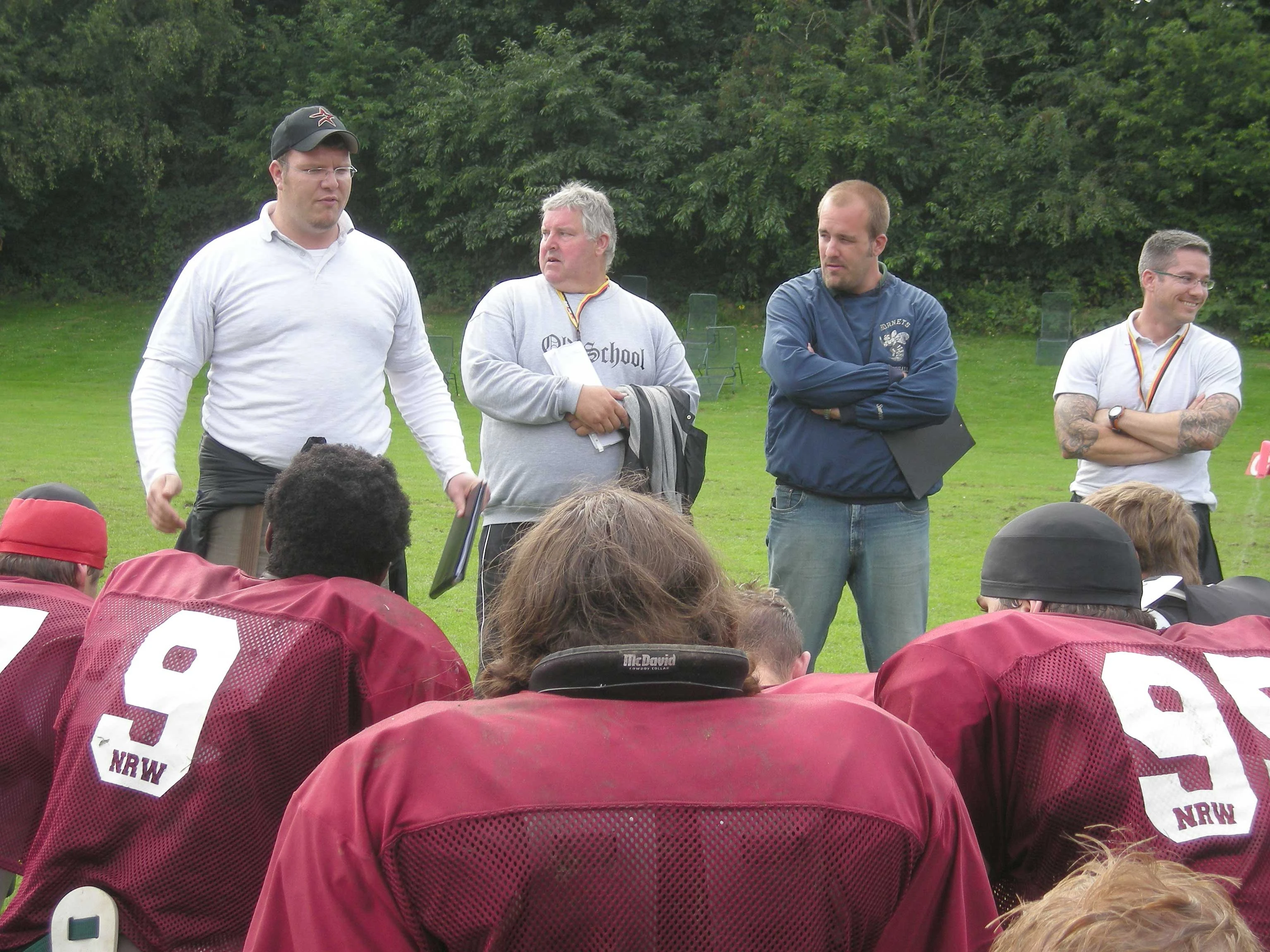Trainerquartett instruiert American Footballer.