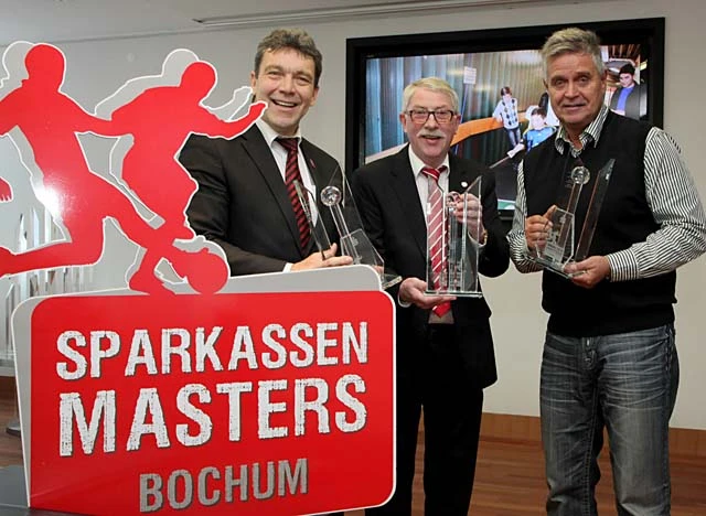 Prüfen schon mal Gewicht und Größe der Pokale für das SparkassenMasters 2014: Jürgen Dieberg von der Sparkasse Bochum (v. li.), Ulrich Jeromín vom Fußballkreis Bochum und Klaus Peters von DjK Arminia Bochum, dem ausrichtenden Verein