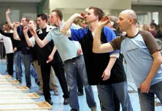 Konzentrierte Dartspieler in Aktion, die mit dem Pfeil in der Hand das Dartbrett anvisieren.
