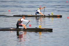 Zwei Kanuten paddeln auf dem Wasser.