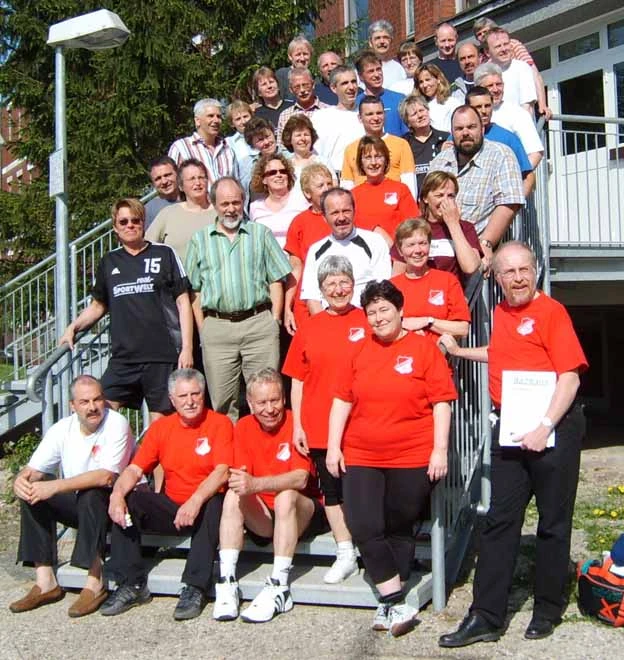 Gruppe von Indiaca-Spielerin stehen auf der Treppe vor einer Sporthalle.