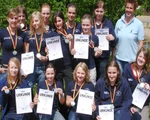 Mannschaft und Trainerin der Wasserballerinnen in blauen T-Shirts.