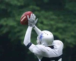American Footballer in blauem Trikot beim Sprung und Fangen.