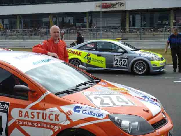 Volker Strycek  mit seinem orange-roten Opel Astra GTC.