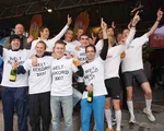 Jubelnde Läufer mit Sektflaschen und Weltrekord-T-Shirts.