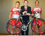 Radsportler des Team Sparkasse mit Rennrad und dem Manager.